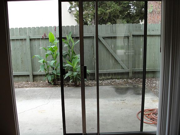 Backyard patio. Please note that the fencing has recently been replaced with white vinyl fencing. Yard has gate for exit and entrance.
