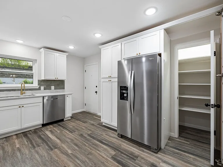 Kitchen featuring white cabinetry, wood-finish flooring, recessed lighting, and a walk-in pantry with shelving
