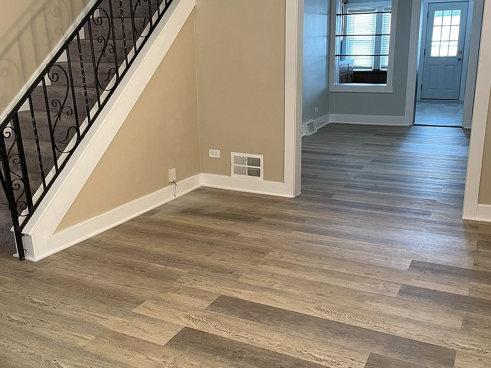 Living room with a view into the dining room and kitchen - all new flooring and paint!