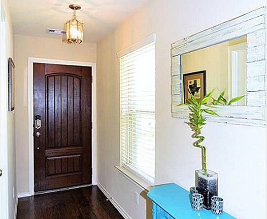 Cheerful Entry with Raised Panel Hardwood Stained Door.