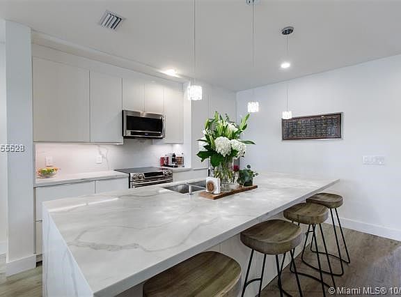 Kitchen with center island sink area, custom quartz counters, Samsung Refrigerator & Microwave, Custom Bosch Oven and is a can b