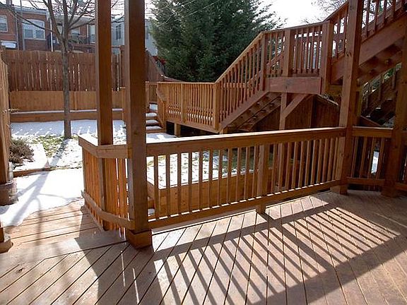 Private deck looking out onto backyard. Back now features landscaping, hardscaping, and 2-car garage.