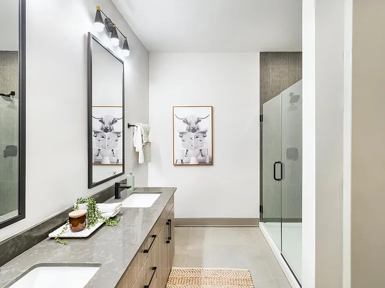 Quartz countertops, a double vanity, and a glass-enclosed shower bring ease and elegance to your private bathroom retreat.