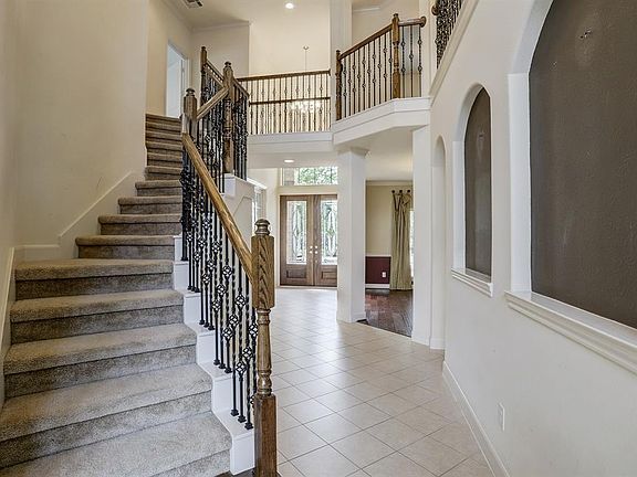 Beautiful wrought iron stair case and view of entry.