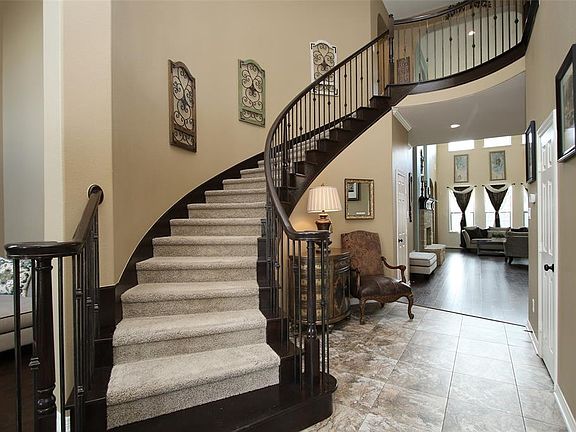 A lovely staircase and curved walls grace the entryway.