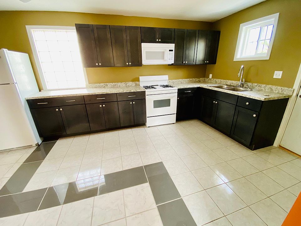 This kitchen has brand new cabinets, countertop, and a new microwave.