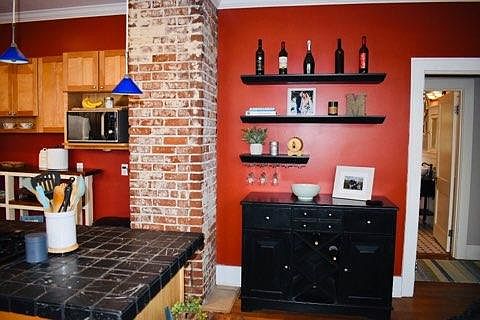 Kitchen island on left. Black cabinet and shelves stay with house.