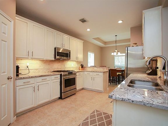 Kitchen has been totally remodeled!   The granite is simply exquisite!   Cabinets have been refinished with the trendy glazing technique plus new hardware.   New stunning travertine backsplash has a subtle accent pattern to it.  All high end GE Cafe Series stainless steel appliances including the the fancy gas stove with a highly sought after gas cooktop.