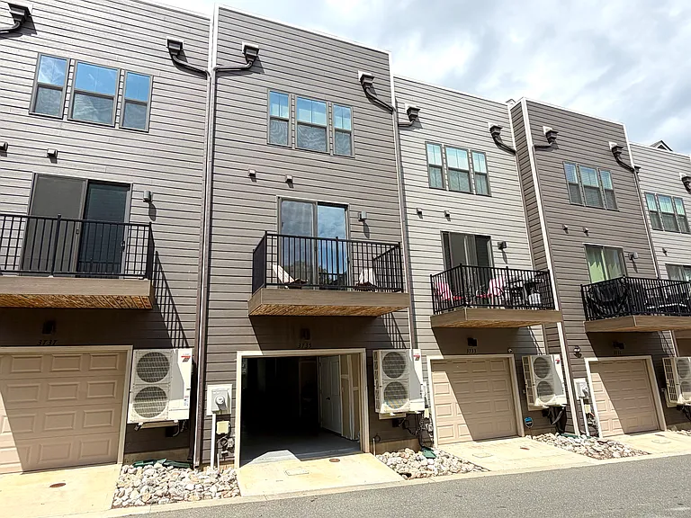 Rear view of townhome: Attached 2 car tandem garage with storage. Also view of main floor balcony.