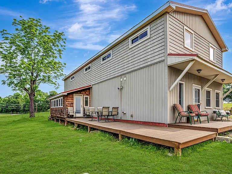 Lovely side porch, over looking a large field & silo.