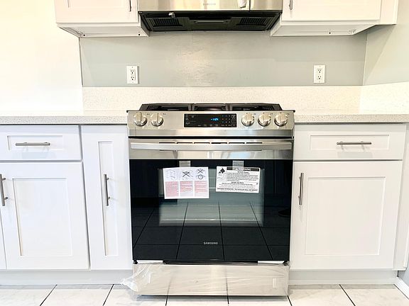 New cabinets, countertops, stove range, oven, and microwave.