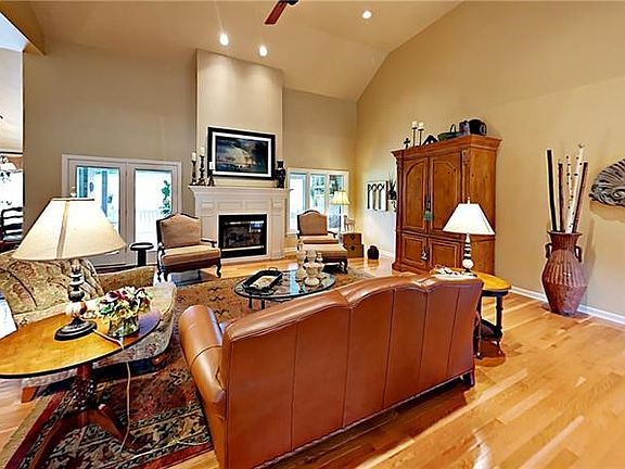 Two story living room with recessed lighting, ceiling fan, and gas fireplace.