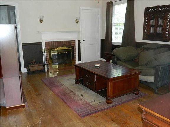 Come on in living area with a fireplace and a closet.  Original hardwood floors.