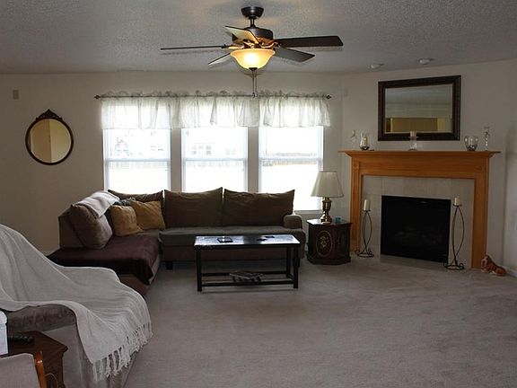 Spacious great room with ceiling fan and light.