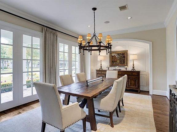 Pretty dining room with windows across the front. Paneled alcove allows for an elegant setting