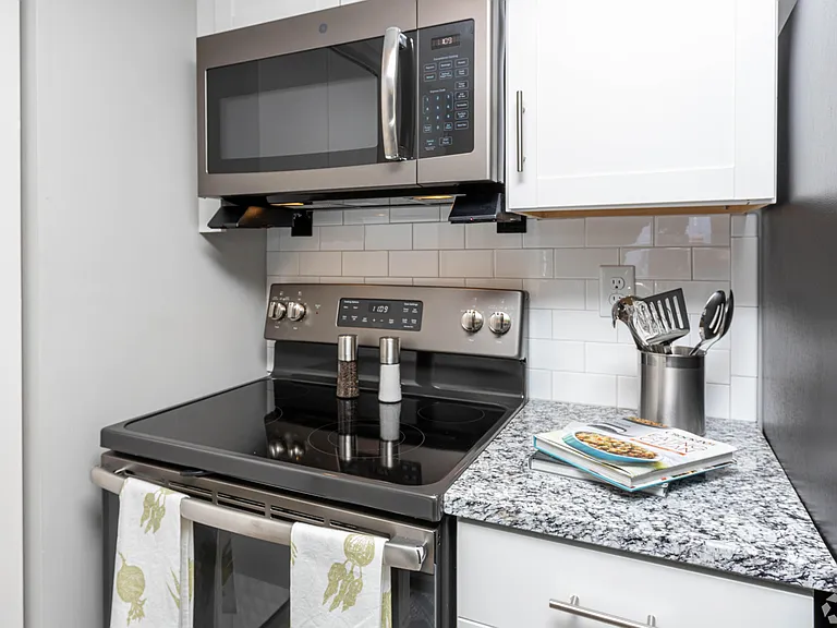 Kitchen with granite counters, subway-tile backsplash, and stainless appliances
