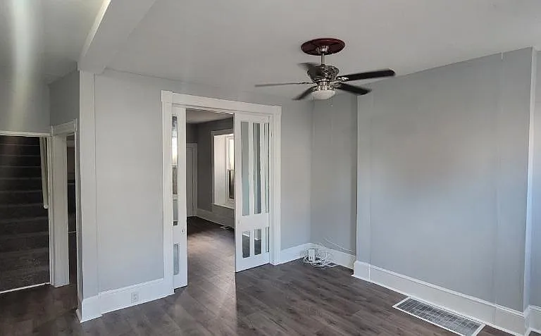 Living room with pocket doors that lead to dining room. View of stairwell that leads to 2nd floor