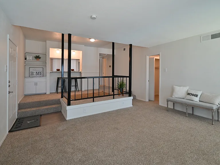 Bright living room with plush carpet and rod iron accent feature