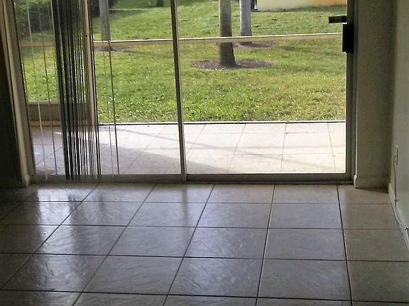 Sliders in LR to screened in patio with view of courtyard an