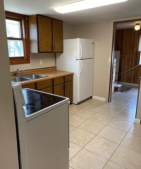 Kitchen with Tile Floor and Mud Room in Rear of Picture.
A portion of the Mud Room has an area to hang a row of clothes, hobby equipment etc. The side entrance to the house is where the mud room is.