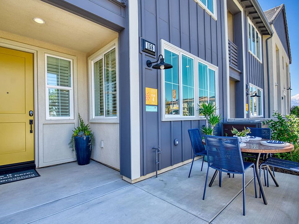 Exterior front entry of Citrus at Canvas Park Residence 4 with patio set and yellow front door