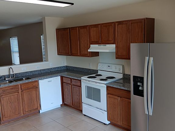 Kitchen with granite countertops and stainless steel fridge