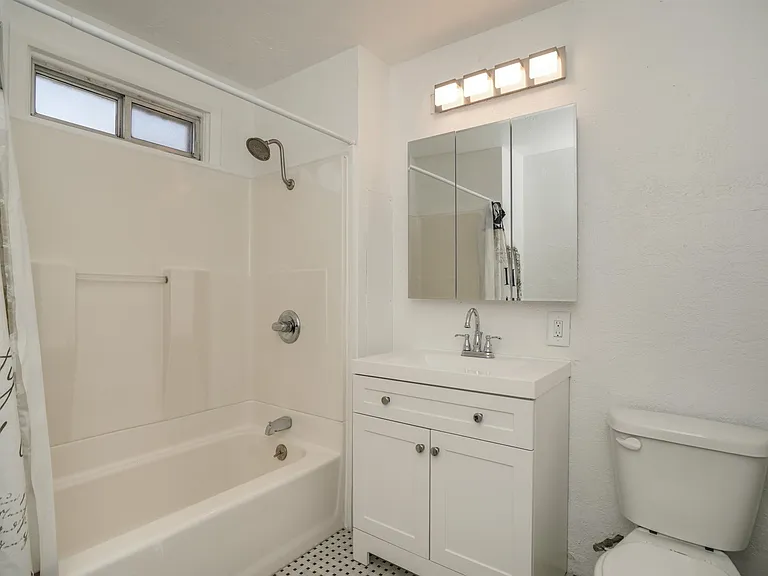 Cheerful Light Bathroom with 
Tub Shower located between Bedrooms