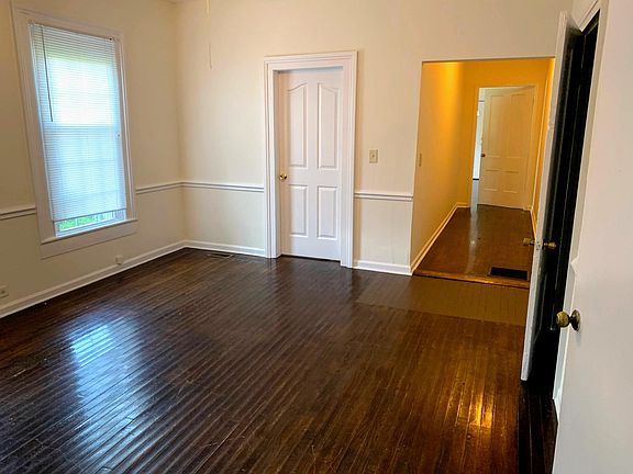 Living room area. The 1st bedroom is through the pictured door. The property has hardwood floors