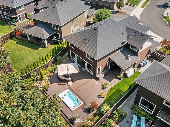 This home offers everything you need~Dip in the swim spa, enjoy covered outdoor living with fireplace and drop down tv and entertain on your expansive deck~Fenced backyard with greenbelt offers privacy and nature