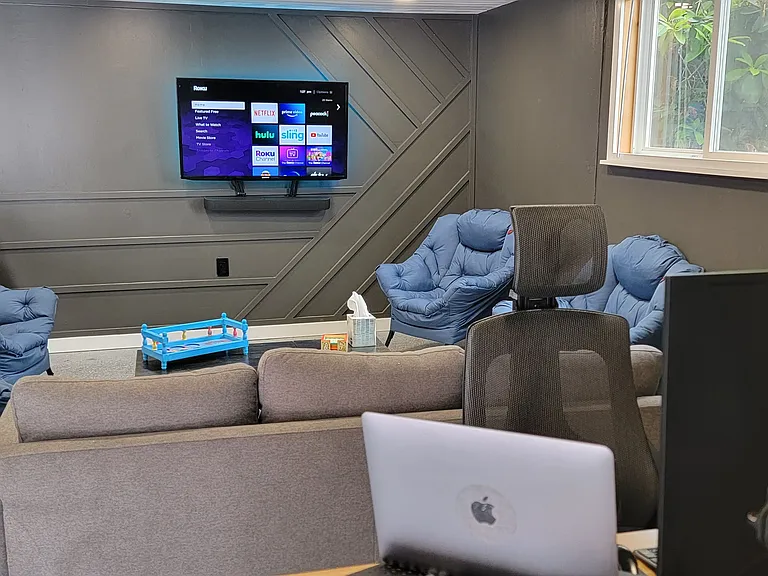 Garage. Was used as seating area with 43 inch mounted TV. Furniture, desk and screen available in furnished option