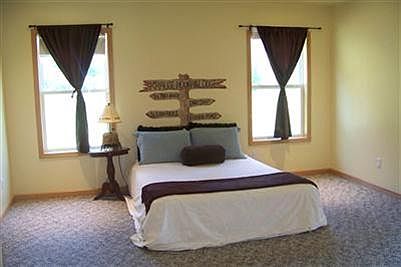 Master bedroom with sliding doors to the wrap around, covered porch.