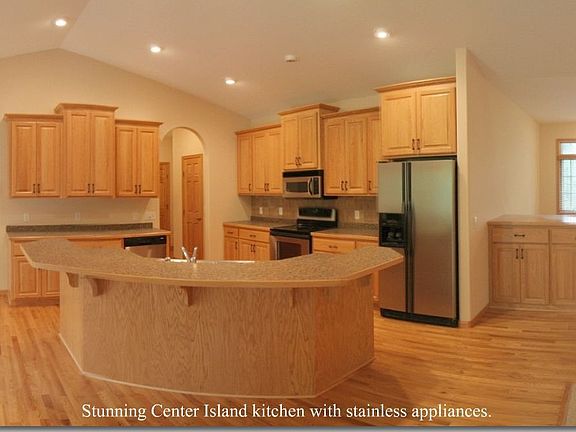 Grand kitchen with stainless appliances, hardwood floors and 42" cabinets.