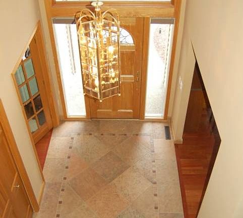 This open and inviting two story foyer has beautiful tile flooring.
