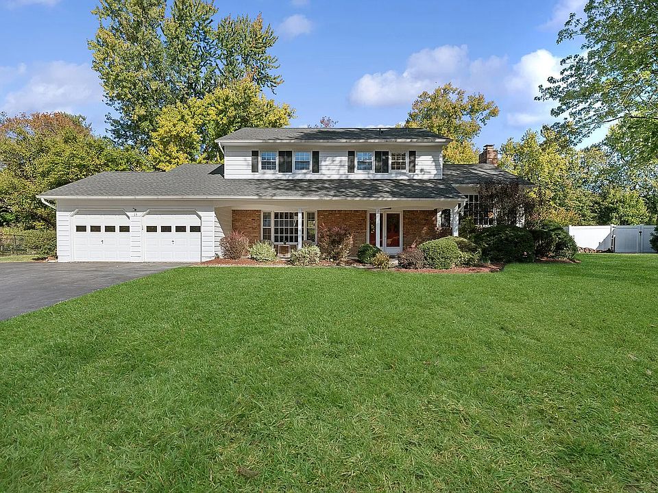Colonial-Style Suburban Home with Two-Car Garage and Manicured Lawn