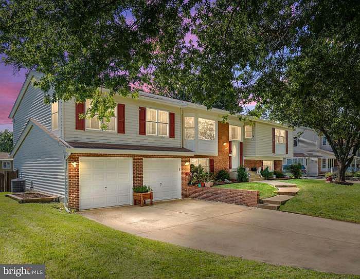 Spacious two-car exterior parking with access to two-car garage and paved pathway to home entrance.