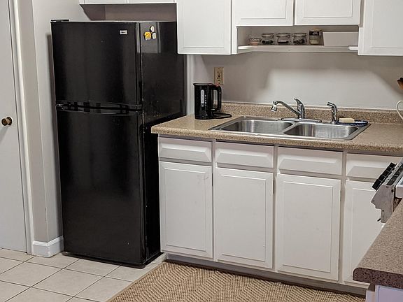 Kitchen from dining area. Pantry to left of refrigerator.