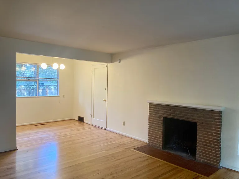 The Living/Dining Room includes hardwood floors and a cozy wood-burning fireplace.