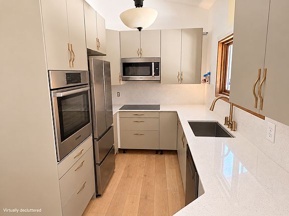 Updated kitchen with Bosch appliances, quartz countertop, ample cabinet storage, and a window over the sink. Virtually decluttered