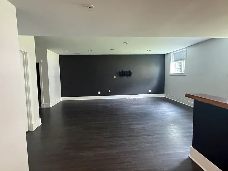 Bright and spacious basement living area filled with natural light from the full-size windows.