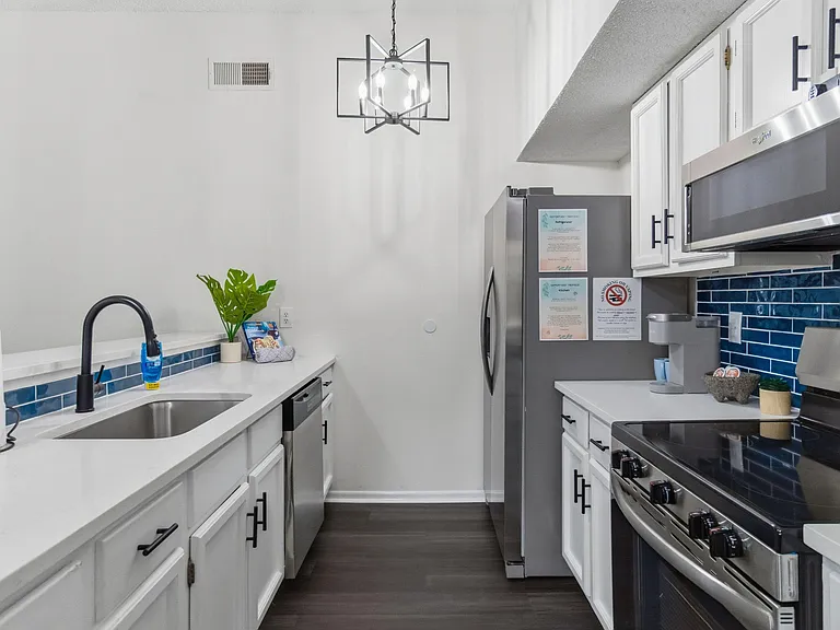 Galley-style kitchen with ample white cabinetry, stainless appliances, and generous counter space for everyday cooking.