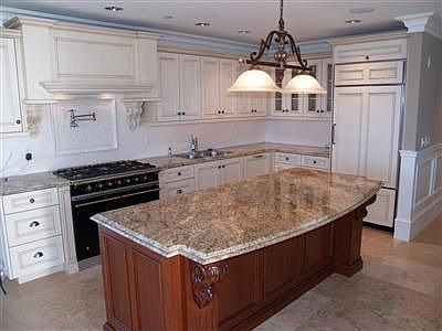 Custom cabinetry by Austrian Millworks, handcarved corbels, slab granite with double radius corners 