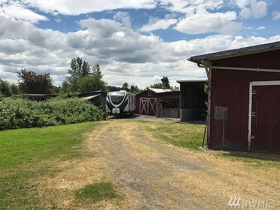 Located on the southwest side of the property are several barns, both modern and original to the farm.  Beyond the buildings is the back field. 