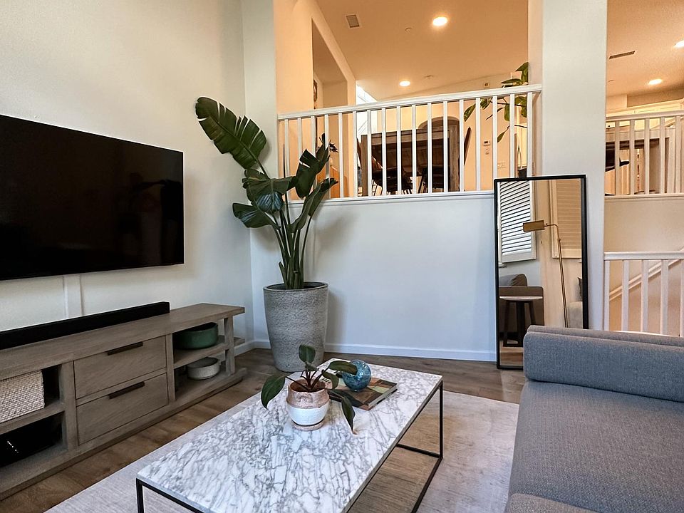 Living room has high ceilings and is located 1/2 floor below dining and kitchen area.