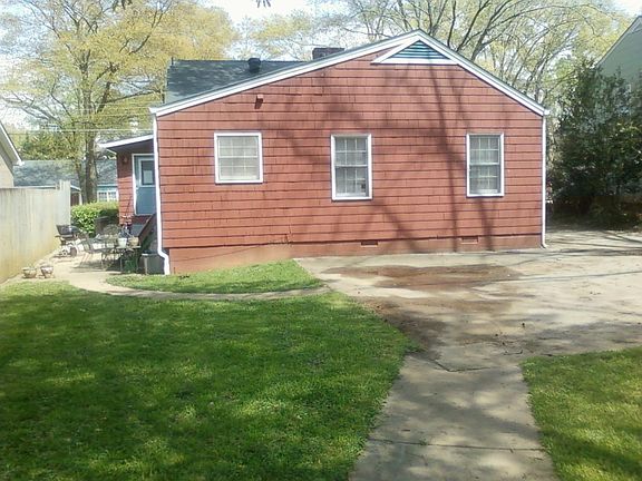 Back view of house and patio area with off street parking area