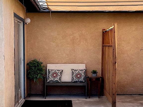 Entrance to guest house with charming patio and sunshade.