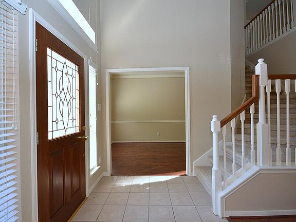 The leaded glass front door opens to a soaring ceiling, tile flooring, the staircase and plenty of n