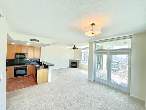 Living/Dining Area has Gas Fireplace, Large Balcony with SW Views (South Bay, Coronado Bridge, Library Dome, Downtown Cityscape, El Cortez Hotel, Central Bay, Spectacular Sunsets, Airport/Runway, Sea World), Several Operable Windows, Ceiling Fan and Light