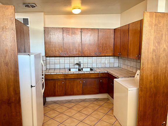 Kitchen with tile countertops and double sink with pull-out faucet