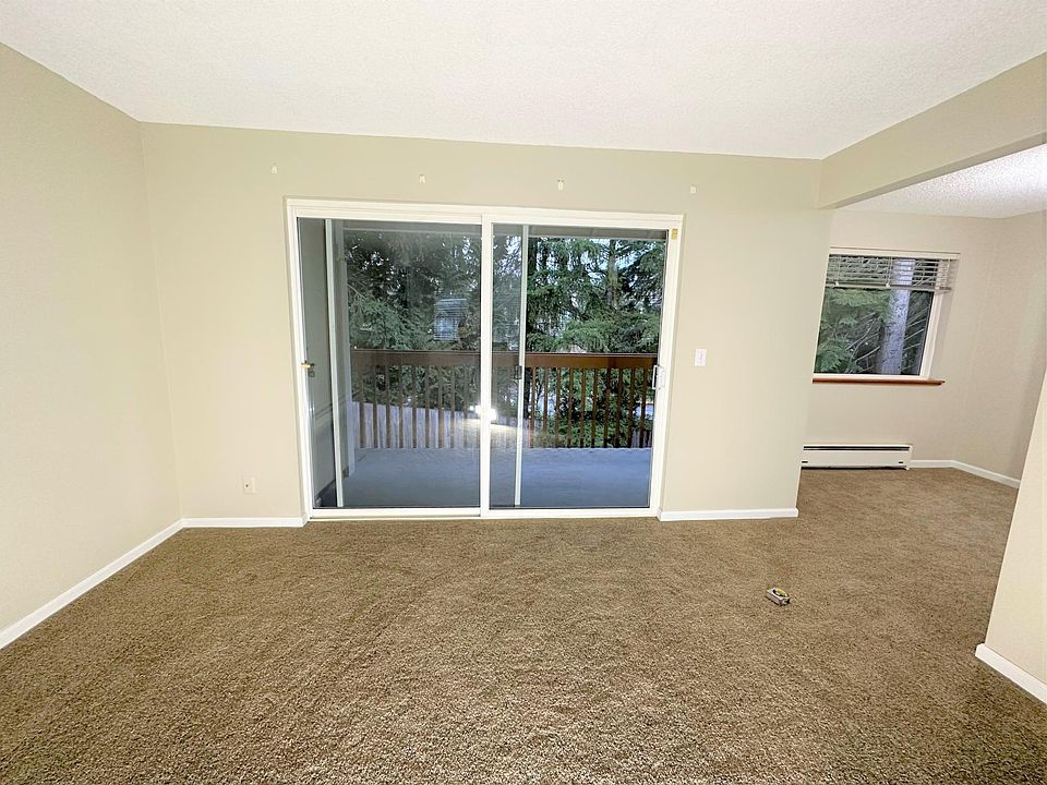 Large living room with view of large deck. Natural surroundings for pleasant ambiance.
