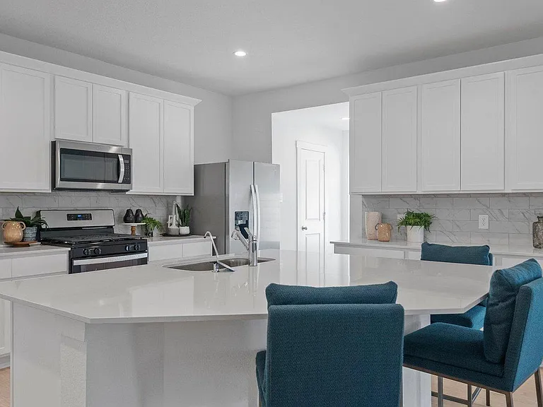 Open kitchen with a large island, ample cabinet storage, and stainless steel appliances, plus bar seating for easy meals.